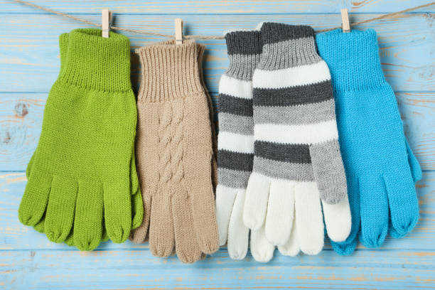 istock Knitted mittens hanging on blue wooden background 1189072361