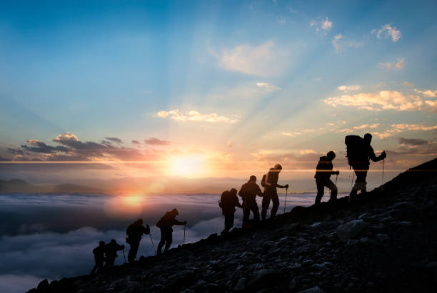 silhouettes of hikers at sunset - montanhismo imagens e fotografias de stock