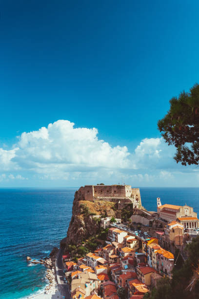 castle Ruffo in Scilla Calabria with awesome cloudscape retro vintage toned Typical view on castle Ruffo in Scilla Calabria with awesome cloudscape retro vintage toned vertical shot. castle scilla stock pictures, royalty-free photos & images
