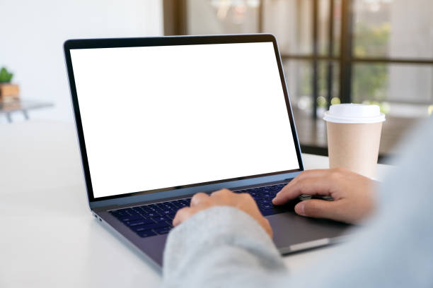 istock a woman using and typing on laptop with blank white desktop screen with coffee cup on the table 1189079438