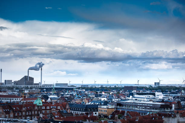 The cityscape of Copenhagen on a beautiful cloudy sunny day. The offshore wind turbine farm Middelgrunden consists of 20 turbines, produces up to 85,000MWh of power annually, which makes up about 3% of Copenhagen’s total power consumption.