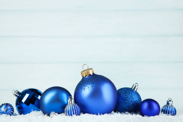 istock Blue christmas balls with snow on wooden background 1189081944