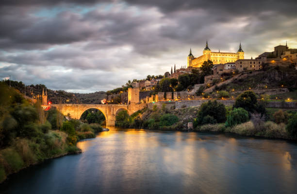 ponte alcazar e alcantara a toledo al tramonto riflesso nel fiume tajo - alcantara bridge foto e immagini stock