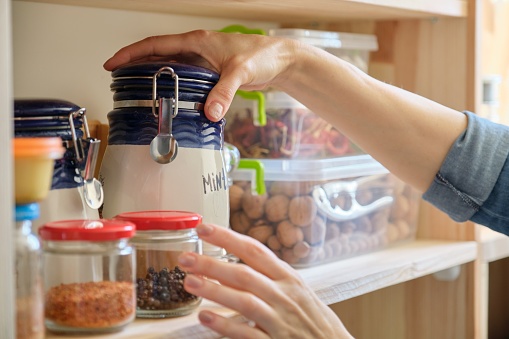 istock Woman in the kitchen with can of dry mint, food storage, pantry 1189084604