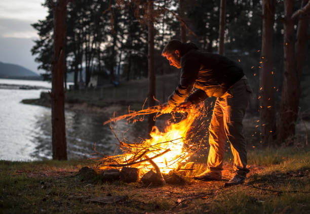 istock Man lights a fire in the fireplace in nature 1189085549