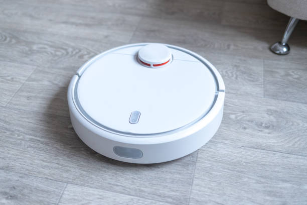 istock Robotic vacuum cleaner on the floor cleaning the room. Smart cleaning technology. 1189085576