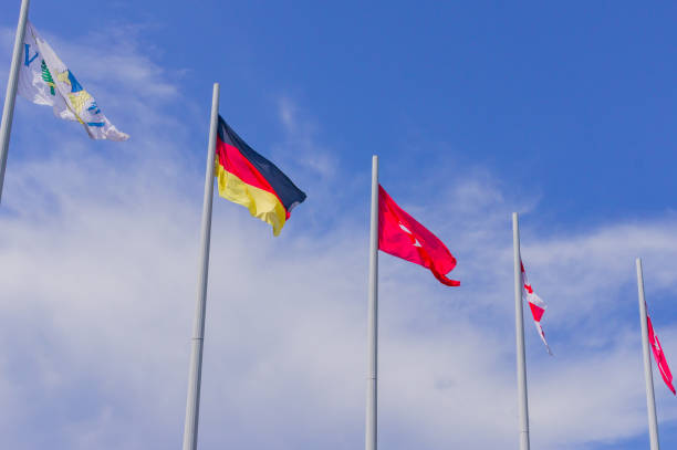 istock Colorful flags from different countries waving on blue sky background 1189086085