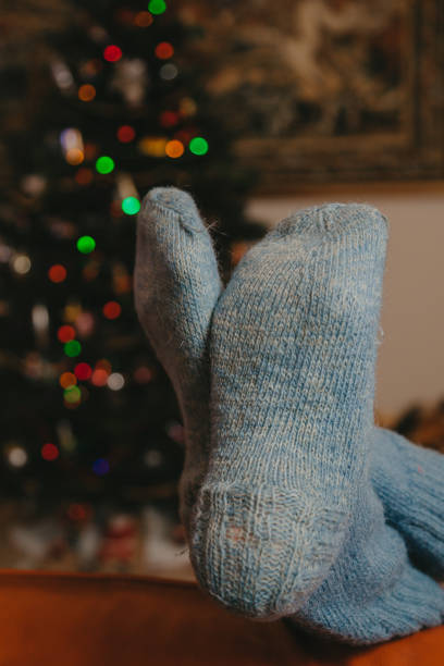 istock Feet in warm socks lie on leather sofa 1189086753