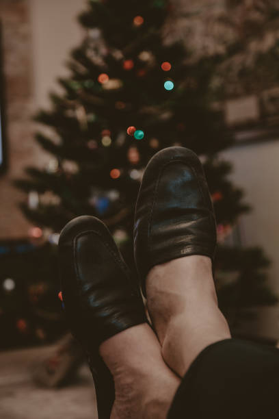 istock Legs in leather slippers lie on white skin closeup 1189087398