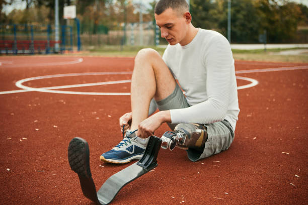 istock Young man with artificial leg tying shoelaces getting ready for training 1189091384