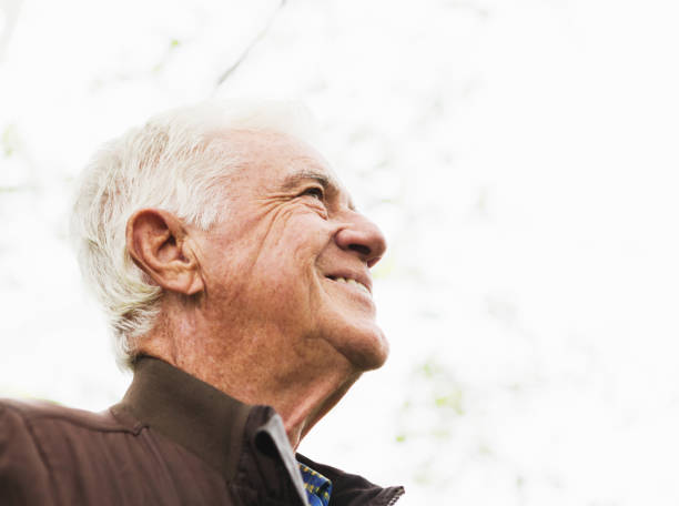 istock White-haired man looking up at bright sky, seen in profile 1189092737