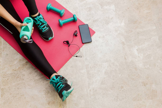 photo courante d'une jeune femme se reposant après avoir exercé à la maison - relaxation exercise audio photos et images de collection