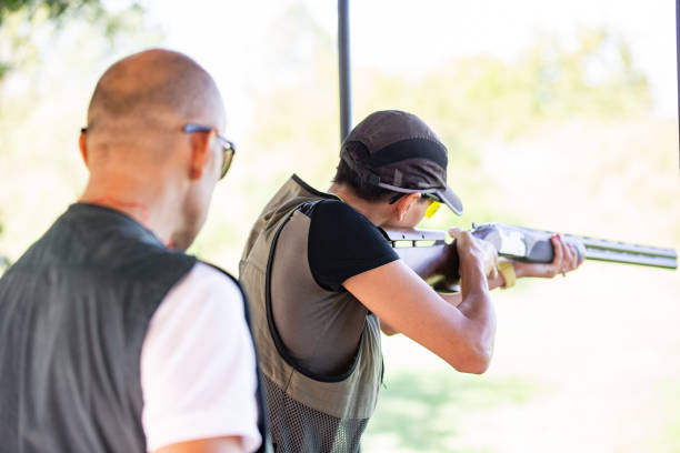 istock Skeet Shooting Coach Watching a Woman Aiming With Shotgun 1189094152