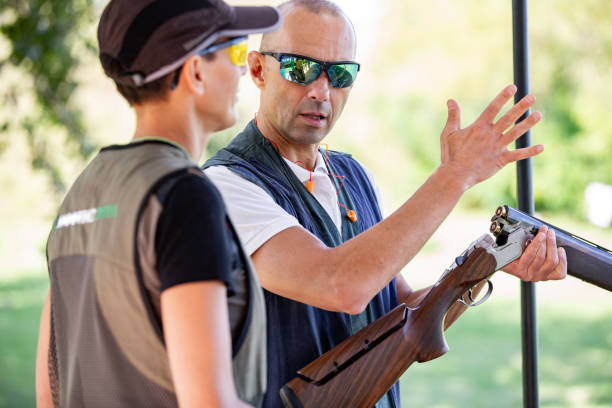 istock Instructor Teaching Adult Woman How To Handle a Shotgun 1189094168