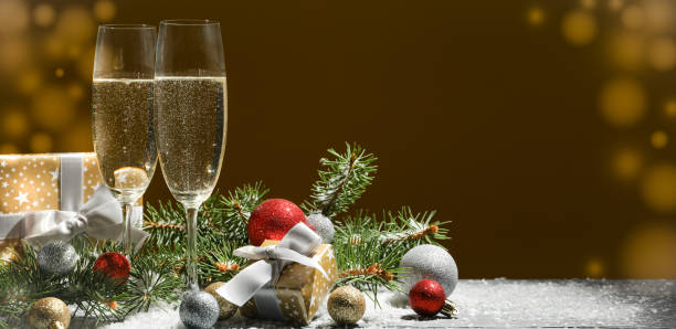 istock Champagne glasses and baubles against golden background, space for text 1189096656