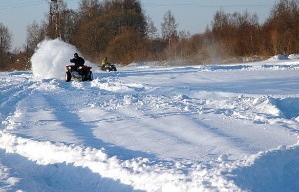 all terrain vehicle in motion at winter stock photo