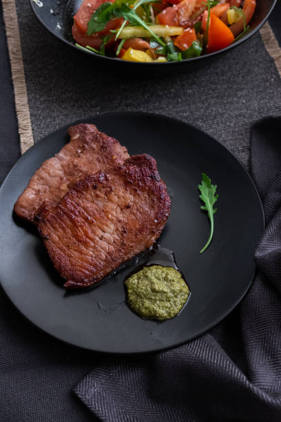 istock medium beef steaks with pesto sauce and vegetable salad. 1189097009