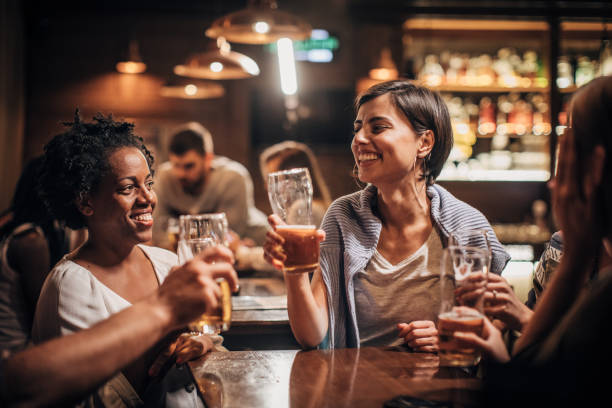 istock Beautiful lady drinking beer with friends 1189097248