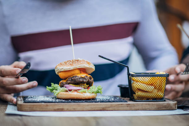 istock Burger and fries in front of a man 1189097529