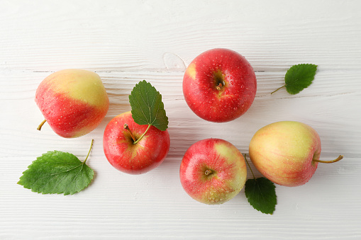 Composition with apples on white wooden background, top view