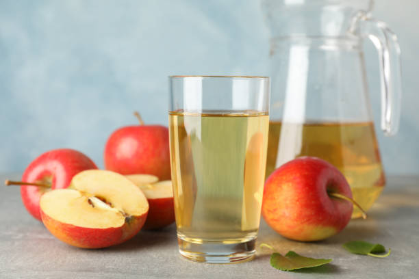 istock Red apples and glasses with juice on grey background, space for text 1189098657