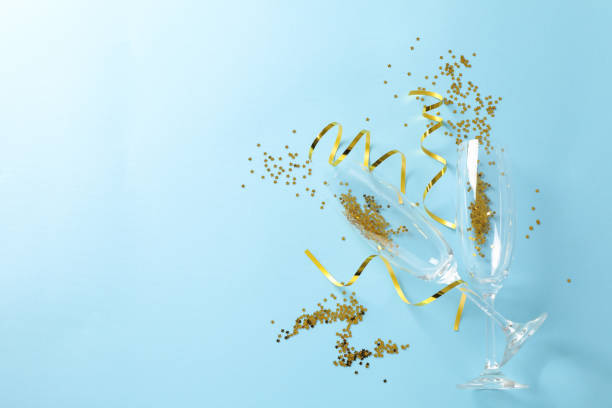 istock Champagne glasses with glitter on blue background, space for text 1189099893