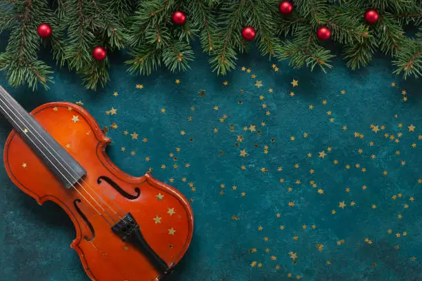 Old violin and fir-tree branches with Christmas decor wits glitter