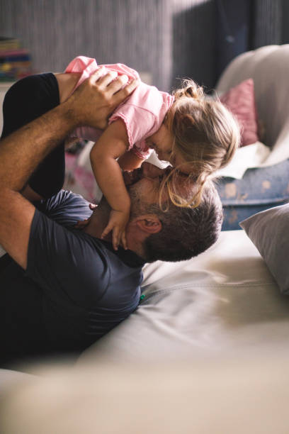 istock Smiling mid adult man having a cuddle while playing with his little daughter 1189100206