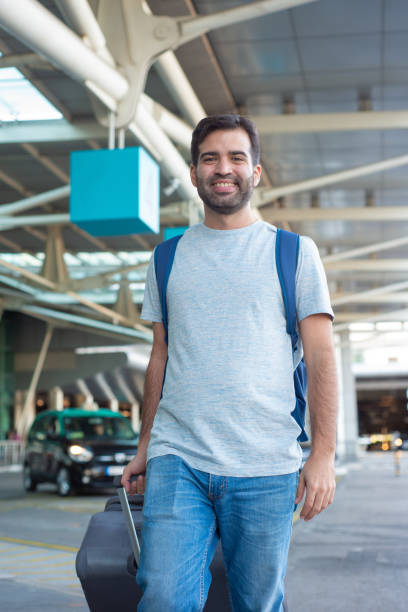 istock Cheerful young man walking near airport 1189100247