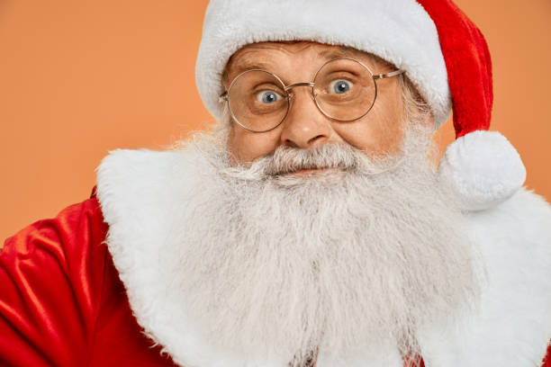 istock Senior bearded man in red Santa costume looking at camera 1189101817