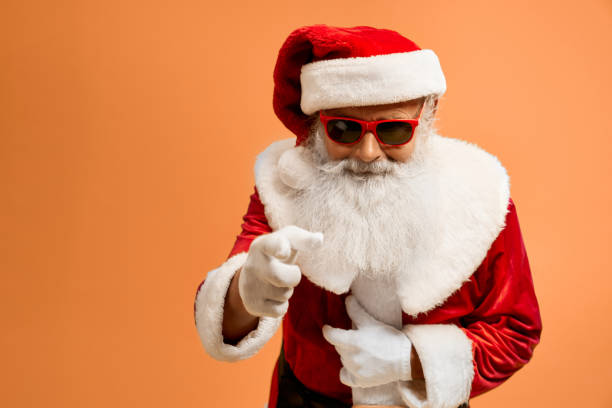 istock Senior man in red Santa costume looking at camera in studio 1189101914