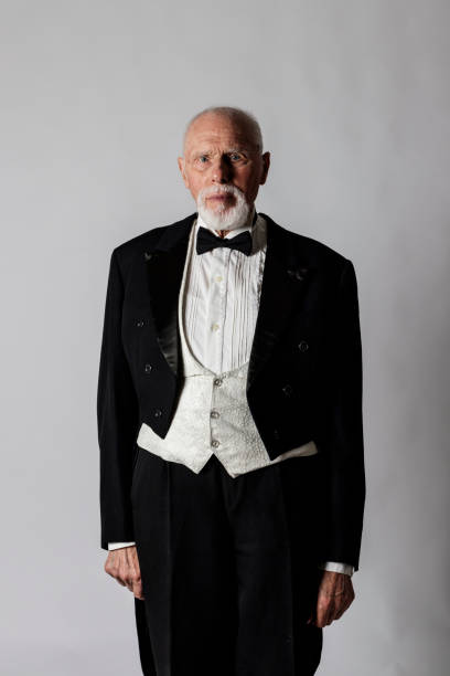 Old man in a tailcoat. Old man in a tailcoat. Portrait of a bearded old man. Senior man dressed in a tailcoat on gray background. tail coat photos stock pictures, royalty-free photos & images