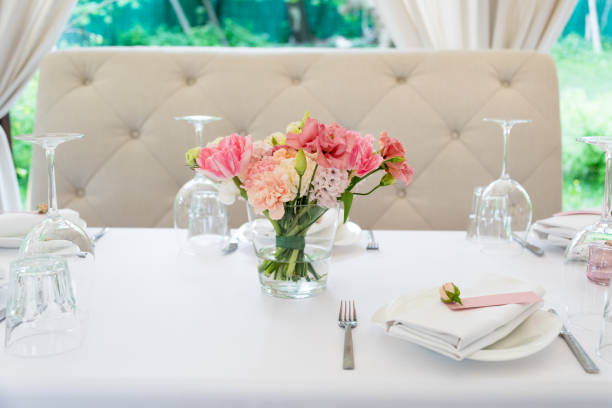 istock Flower table decorations for holidays and wedding dinner. Table set for holiday, event, party or wedding reception in outdoor restaurant. 1189104901