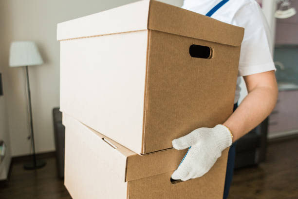 istock Delivery man loading cardboard boxes for moving to an apartment. professional worker of transportation, male loaders in overalls 1189106289