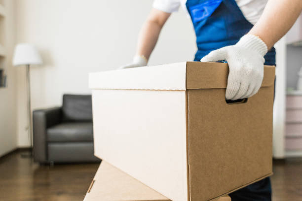 istock Delivery man loading cardboard boxes for moving to an apartment. professional worker of transportation, male loaders in overalls 1189106291