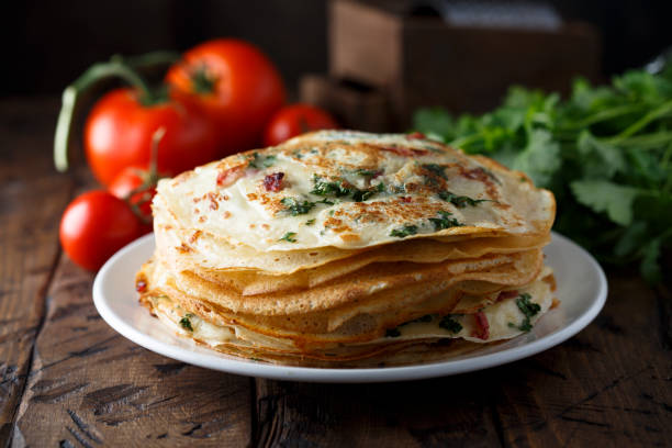 Savory crepes Savory crepes or pancakes with tomato and spinach crêpe pancake photos stock pictures, royalty-free photos & images