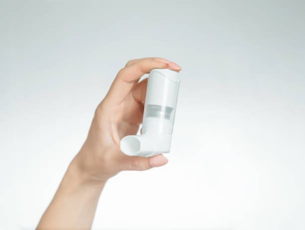 istock Woman's hand holding a medical asthma inhaler. 1189107705