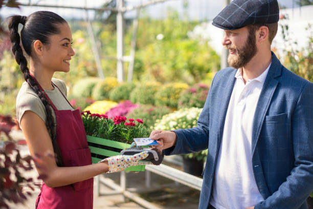 istock Man paying on POS terminal at the greenhouse 1189109584