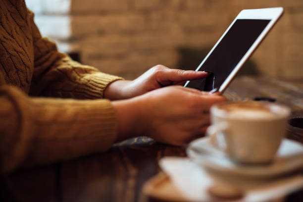 istock Woman uses tablet at desk in cafe 1189112824