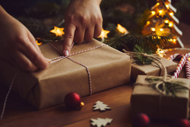 istock Woman wrapping Christmas gift in paper on table 1189112887