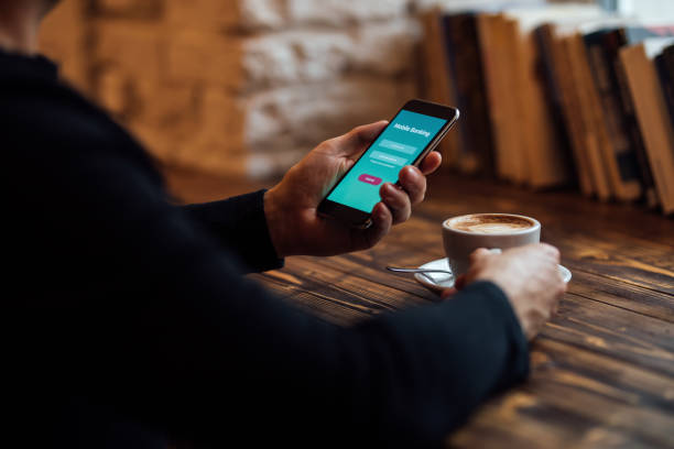 istock Man with cell phone uses internet banking in cafe 1189112923