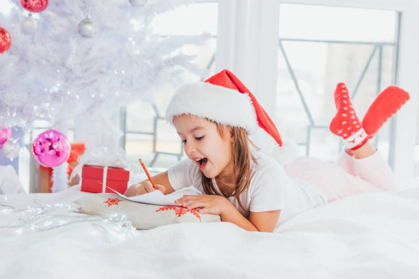istock Expressive little girs is showing with gestures and face expression that mailing with santa is really interesting experience. 1189113267