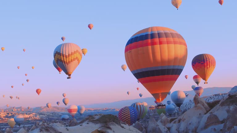 Female traveler with backpack looking to the air baloons. sporty girl and a lot of hot air balloons. The feeling of complete freedom, achievement, achievement, happiness