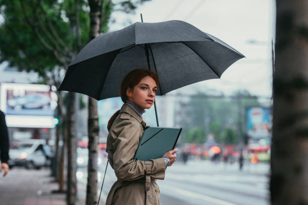 bizneswoman z parasolem stojącym na ulicy - people in a row in a row business office worker zdjęcia i obrazy z banku zdjęć