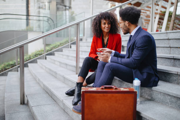 istock Business people sitting on staircase and using mobile phone 1189117551