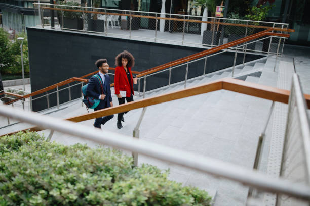 istock Two coworkers climbing up the stairs 1189117863