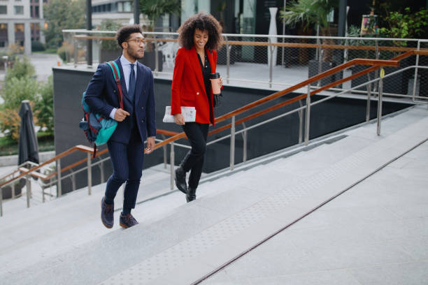 istock Two coworkers climbing up the stairs 1189117934