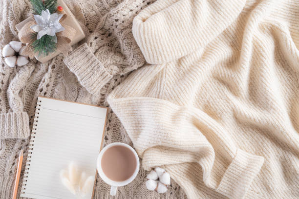 istock Autumn or winter composition. Gift box Coffee cup, notebook, anise stars, beige sweater on cream color knitted blanket background. Flat lay top view copy space. 1189119077