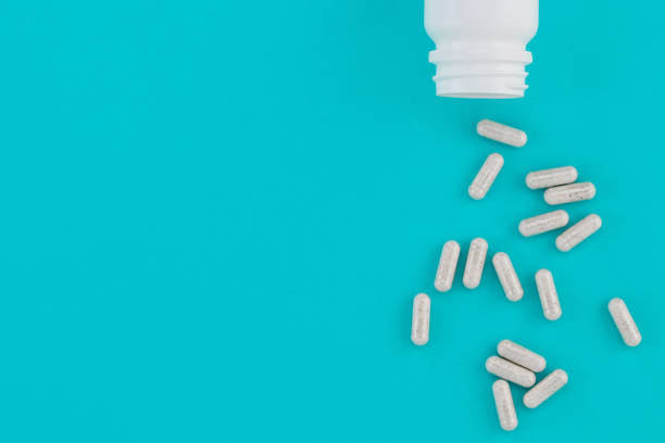 istock Assorted pharmaceutical medicine pills, tablets and capsules and bottle on blue background. Copy space 1189120713