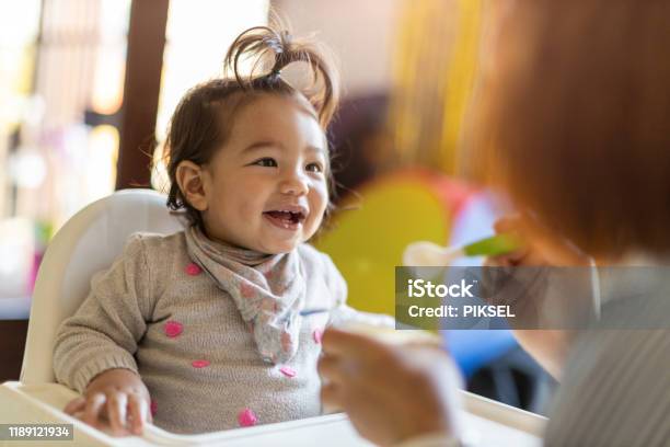 Mother Feeding Her Baby With Spoon Stock Photo - Download Image Now - Baby - Human Age, Eating, Toddler